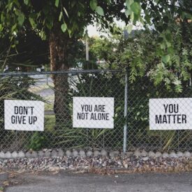 Signs that read: "Don't Give Up", "You are not alone", and "You matter"