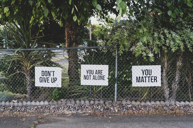 Signs that read: "Don't Give Up", "You are not alone", and "You matter"