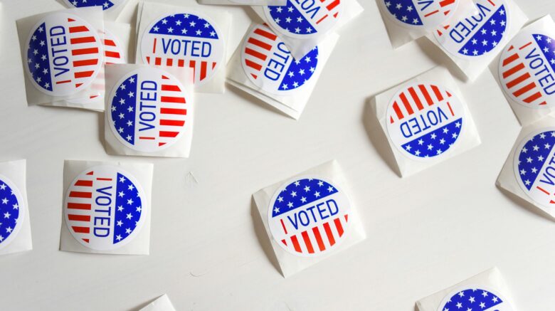 Image of several "I voted" stickers laid out on a table.