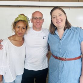 Image of three people smiling and posing for a picture.