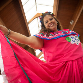 Image of woman smiling in bright cultural dress.