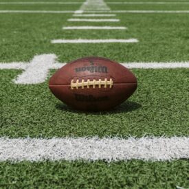 Image of a football placed on a football field.