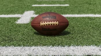 Image of a football placed on a football field.