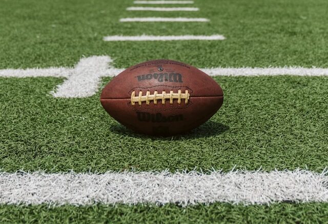 Image of a football placed on a football field.